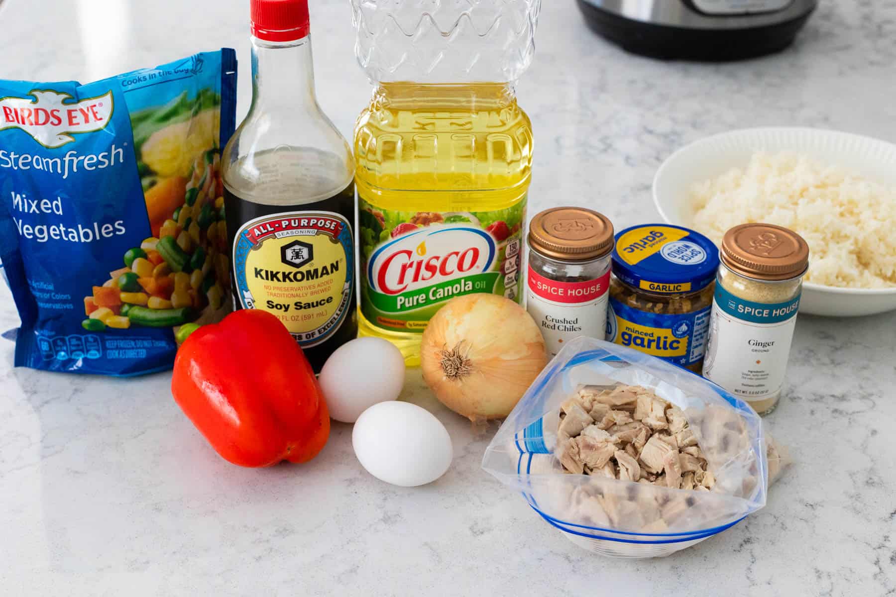 The ingredients to make chicken fried rice are on the kitchen counter.