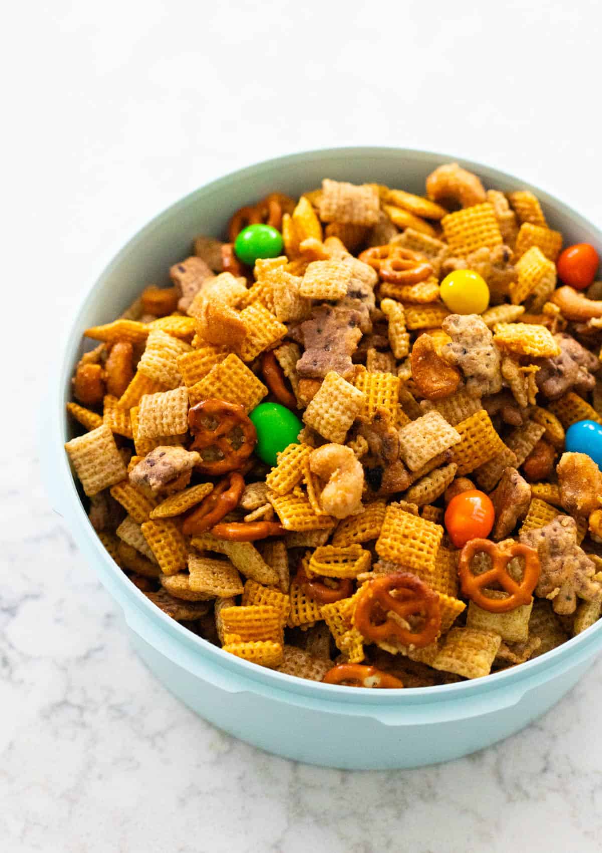 The Chex mix is in a blue bowl ready to take to a potluck party.