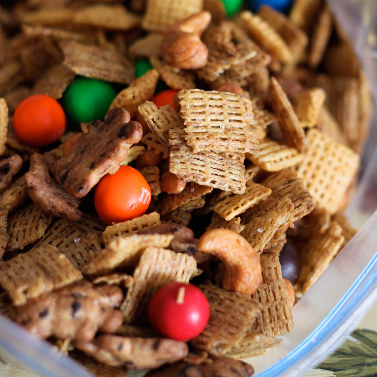 A bag of sweet Chex Mix has nuts, cereal, and red and orange M&M candies.