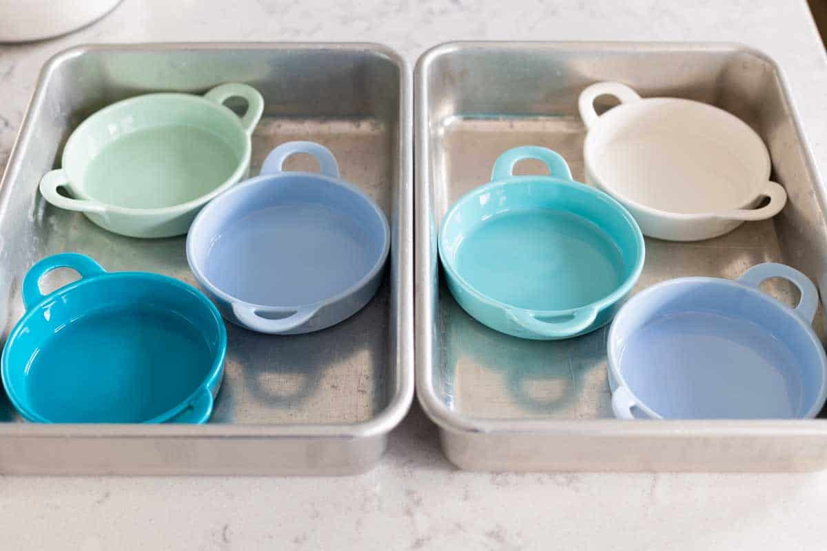 The ramekins and baking pans for the water bath are assembled on the counter.