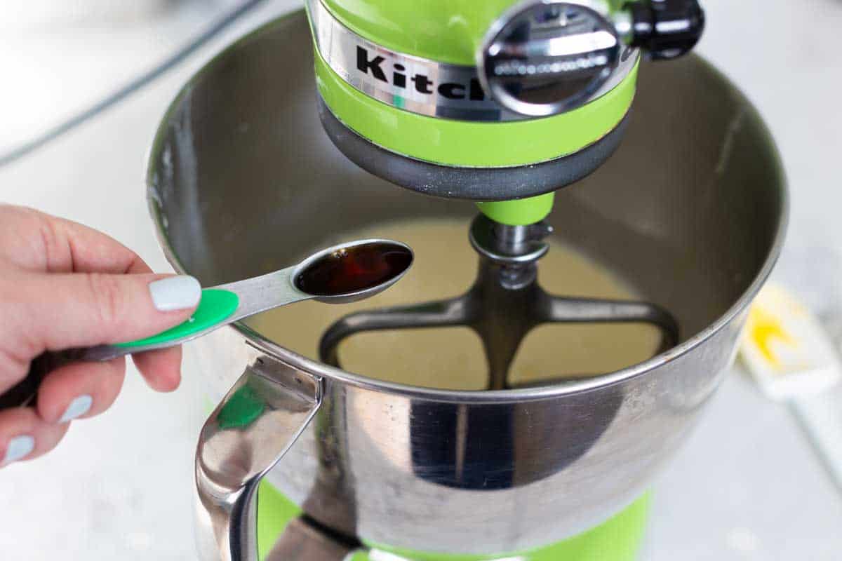 The vanilla is being measured and placed in the bowl.