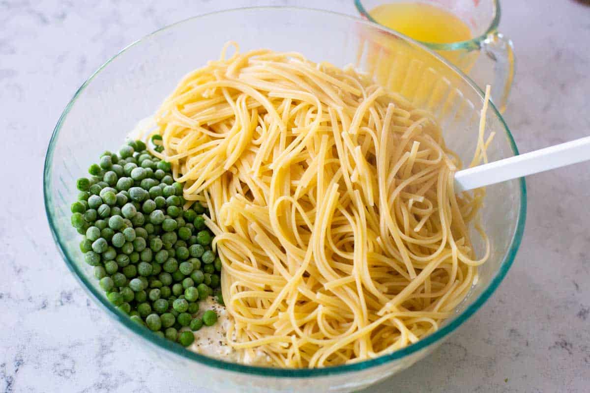 The pasta and peas are about to be mixed into the tetrazzini sauce.