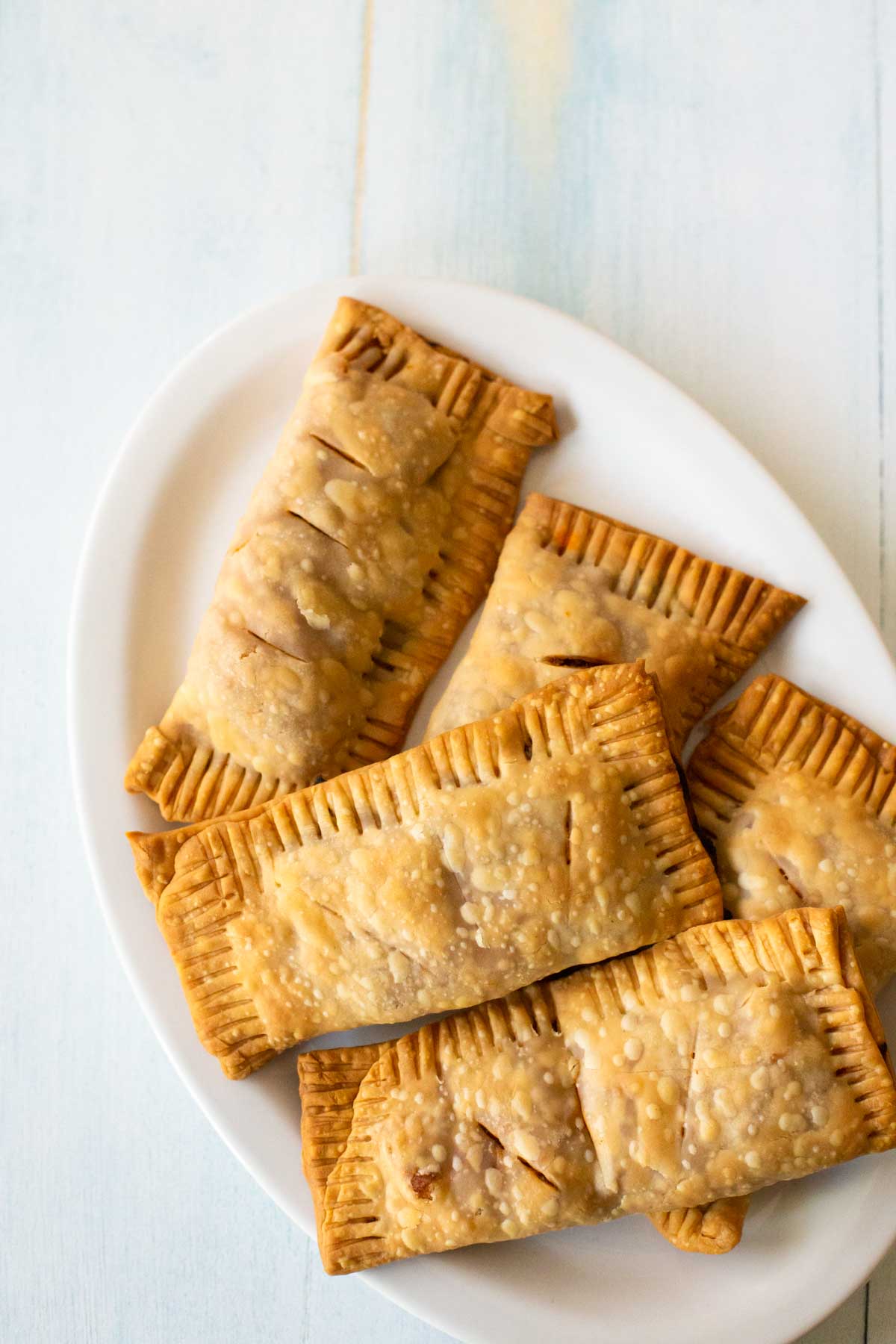 The baked Irish beef hand pies are on a white platter for serving.