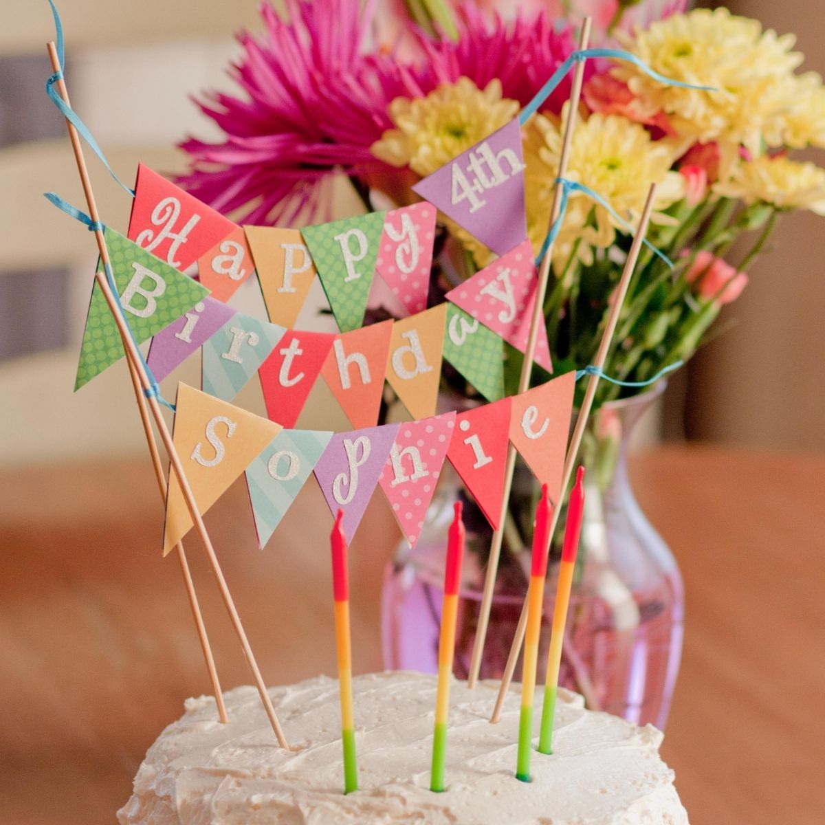 A rainbow papered cake bunting says "Happy Birthday, Sophie."