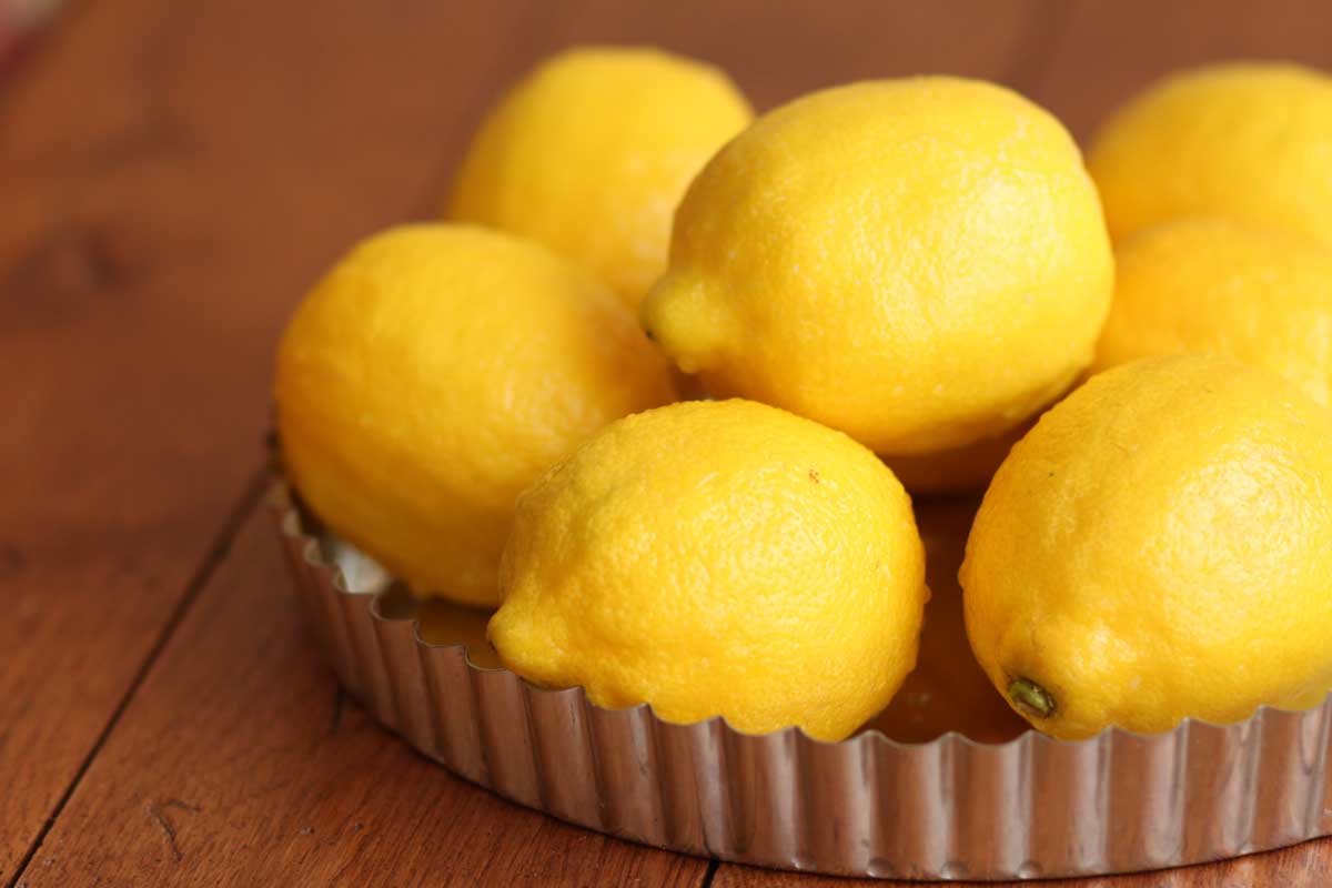 A tart pan filled with fresh lemons.