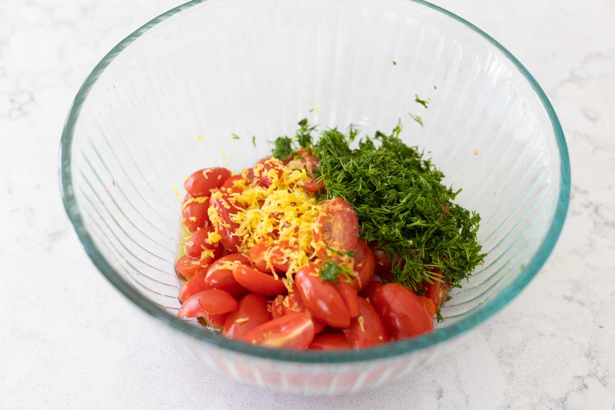 The chopped tomatoes, lemon zest, and fresh dill are in a mixing bowl.