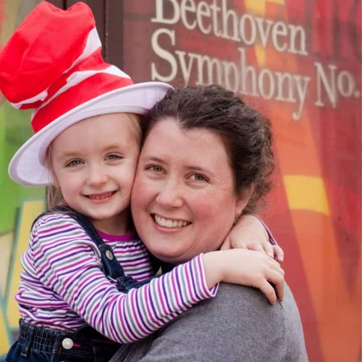 A mom and daughter pose outside a theater to see Seussical the Musical.