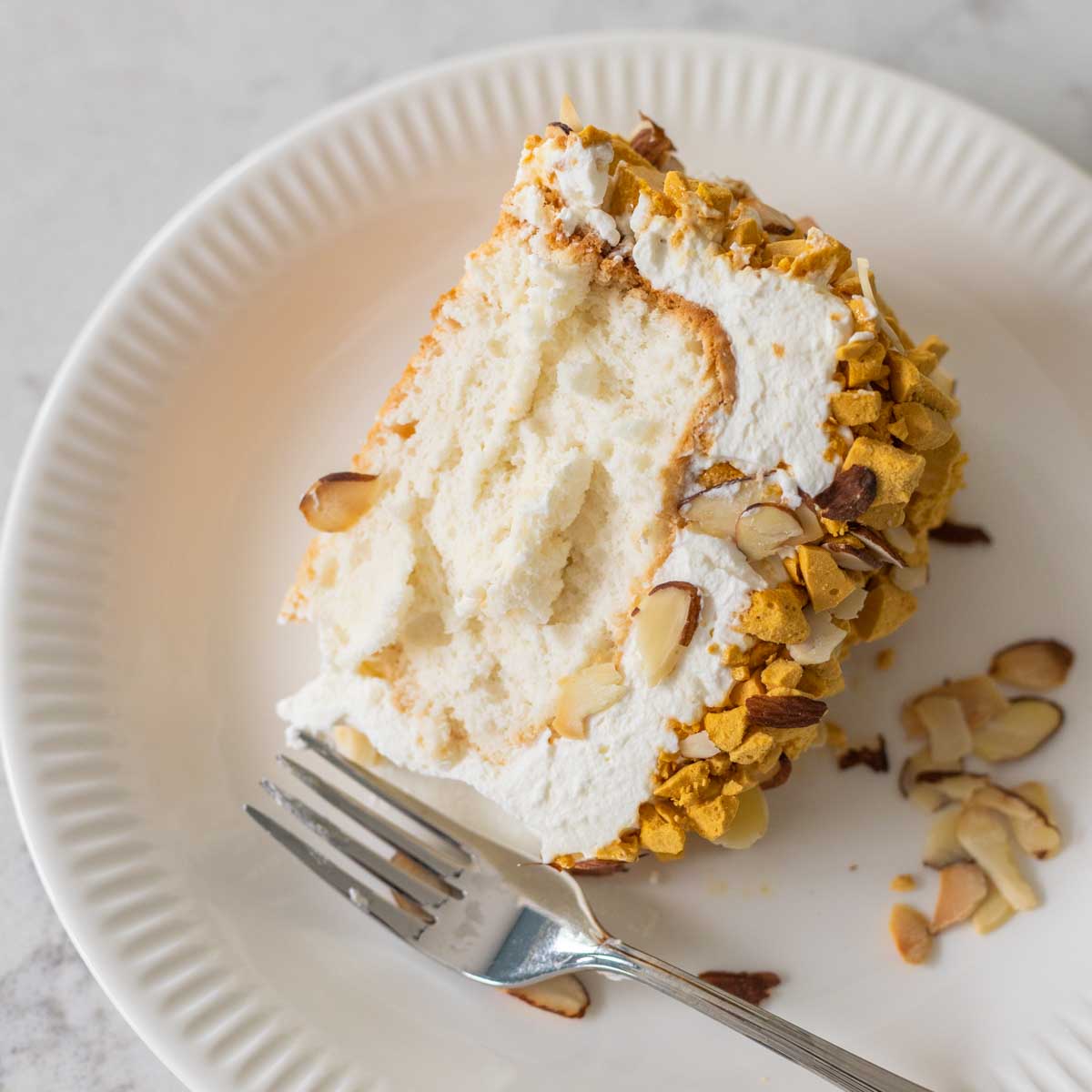 The slice of almond crunch cake is on a plate.