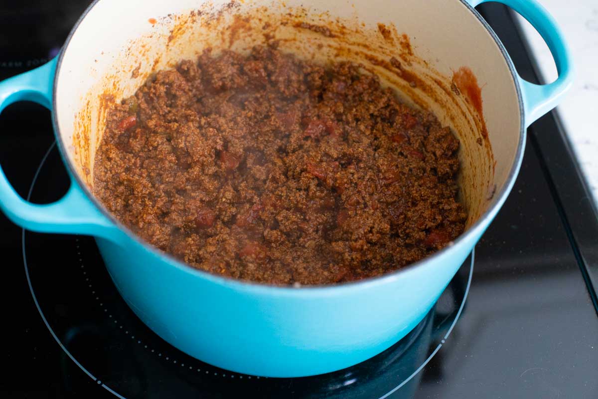 The finished chili is simmering in a big blue pot.
