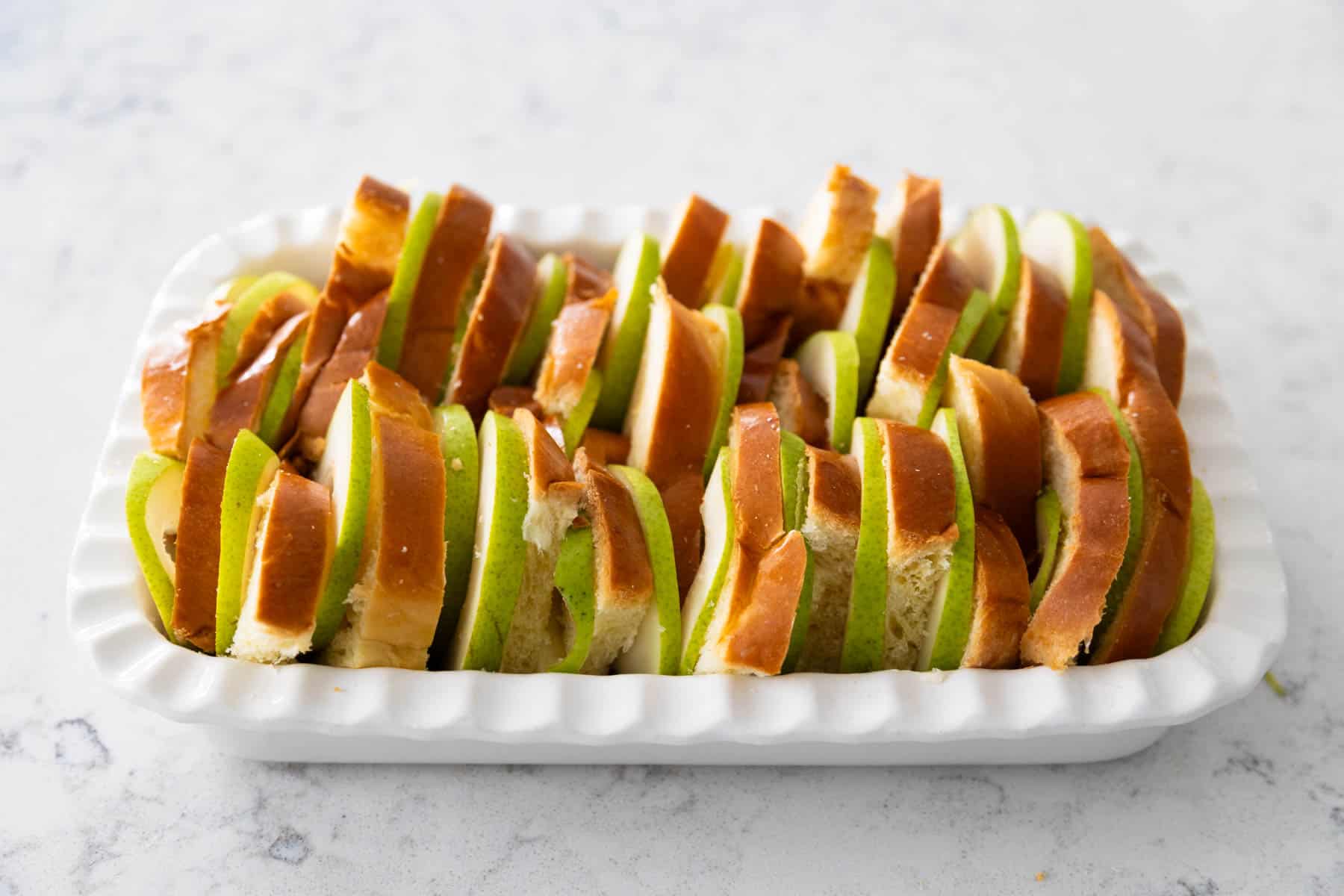 The photo shows the bread pudding from the side so you can see how the sliced bread and pears are tucked tightly into the baking dish.