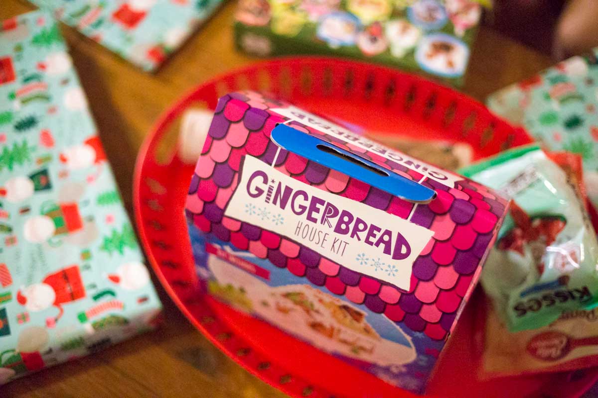 A gingerbread house kit sits on a red tray.
