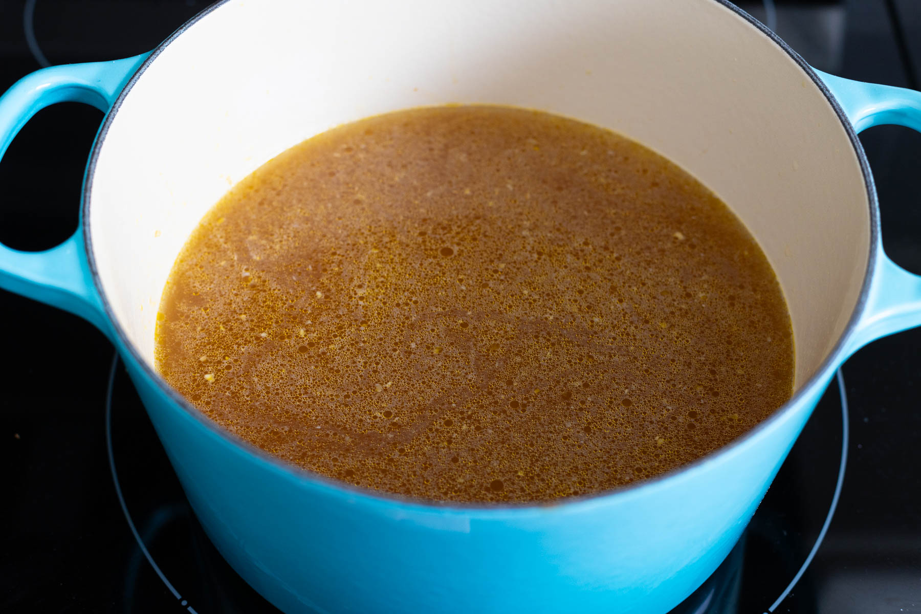 The chicken broth has been added to the soup pot.