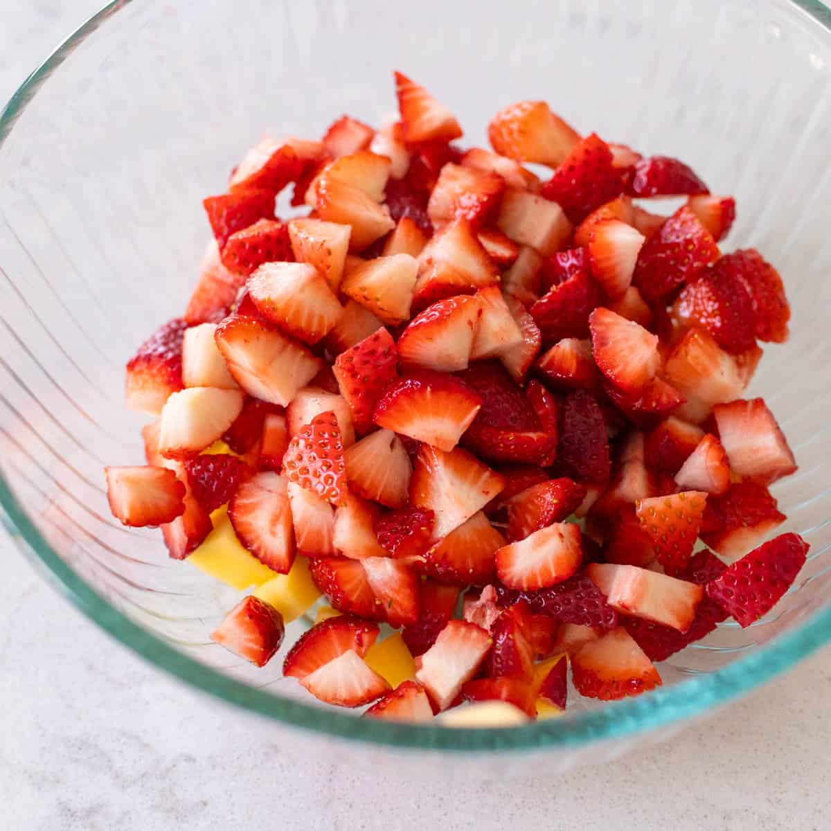 The chopped strawberries have been added to the mixing bowl.