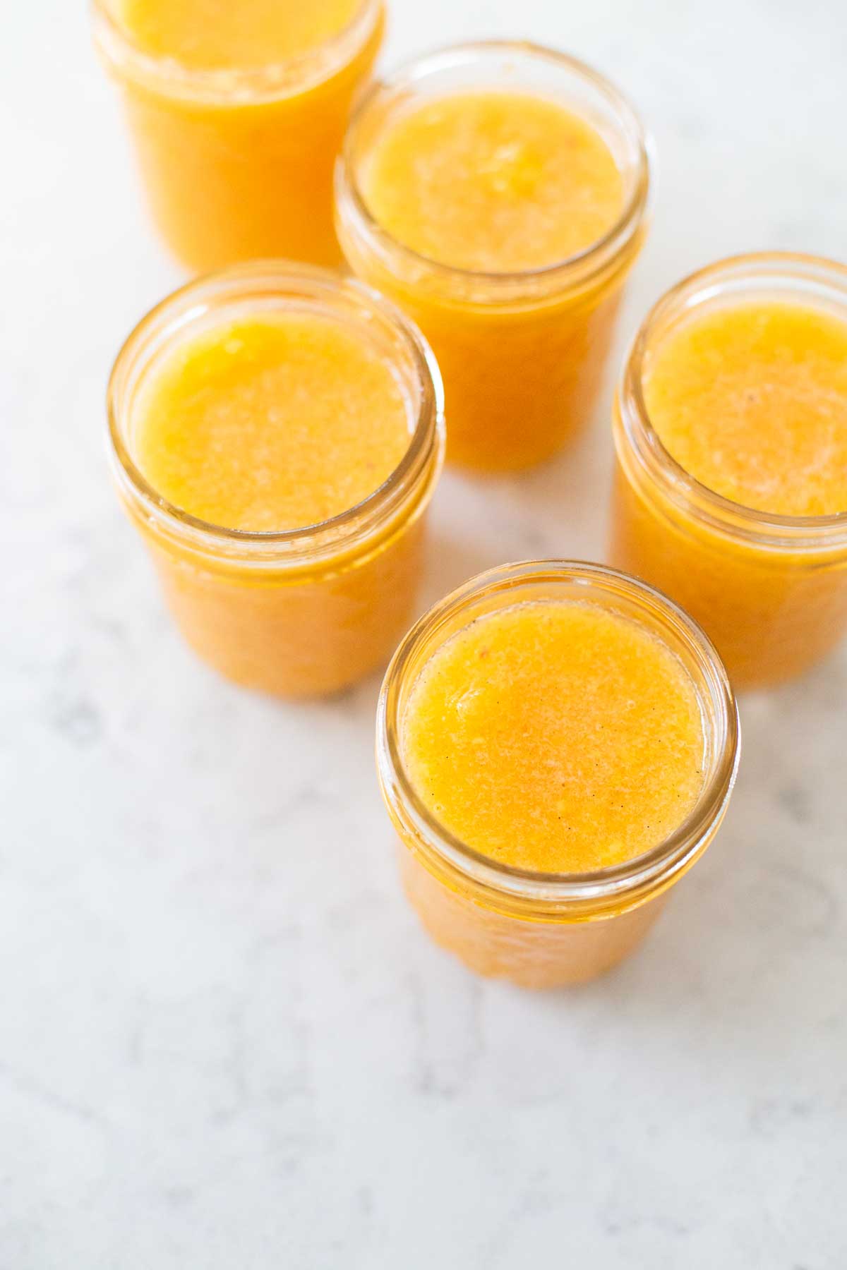 Jelly jars have been filled with fresh peach jam.