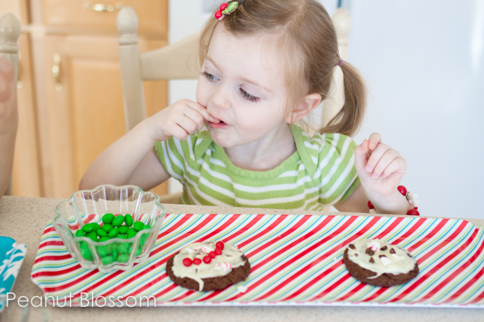 A toddler eats all the holiday candy instead of putting it on top of her chocolate peppermint bark cookies.