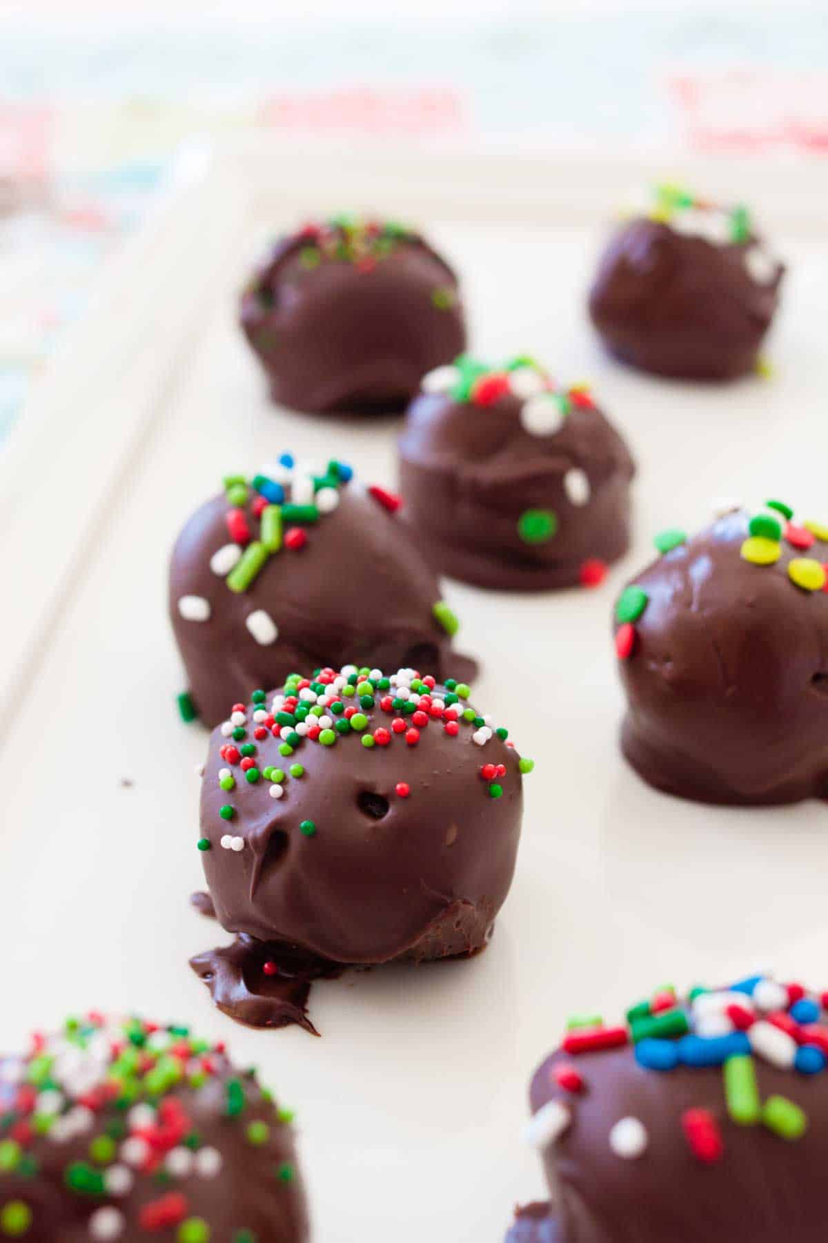 A white serving platter has several Oreo truffles