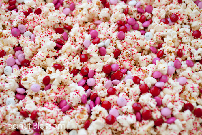 Red and pink popcorn mix has chocolate candies mixed in.