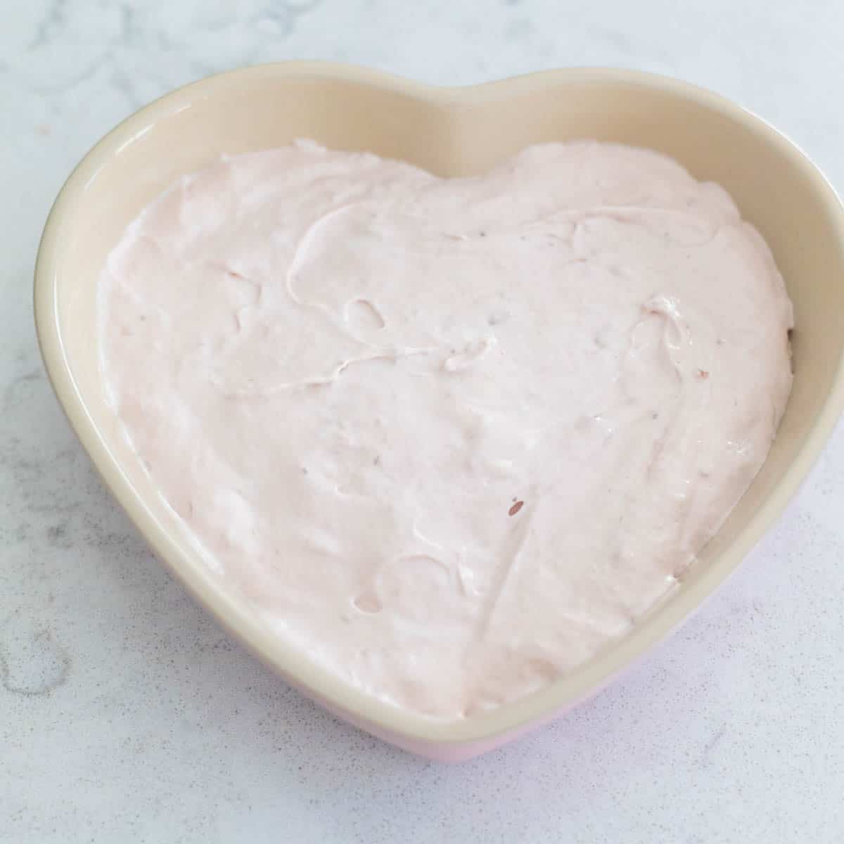 The strawberry dip has been spread into a heart-shaped dish.