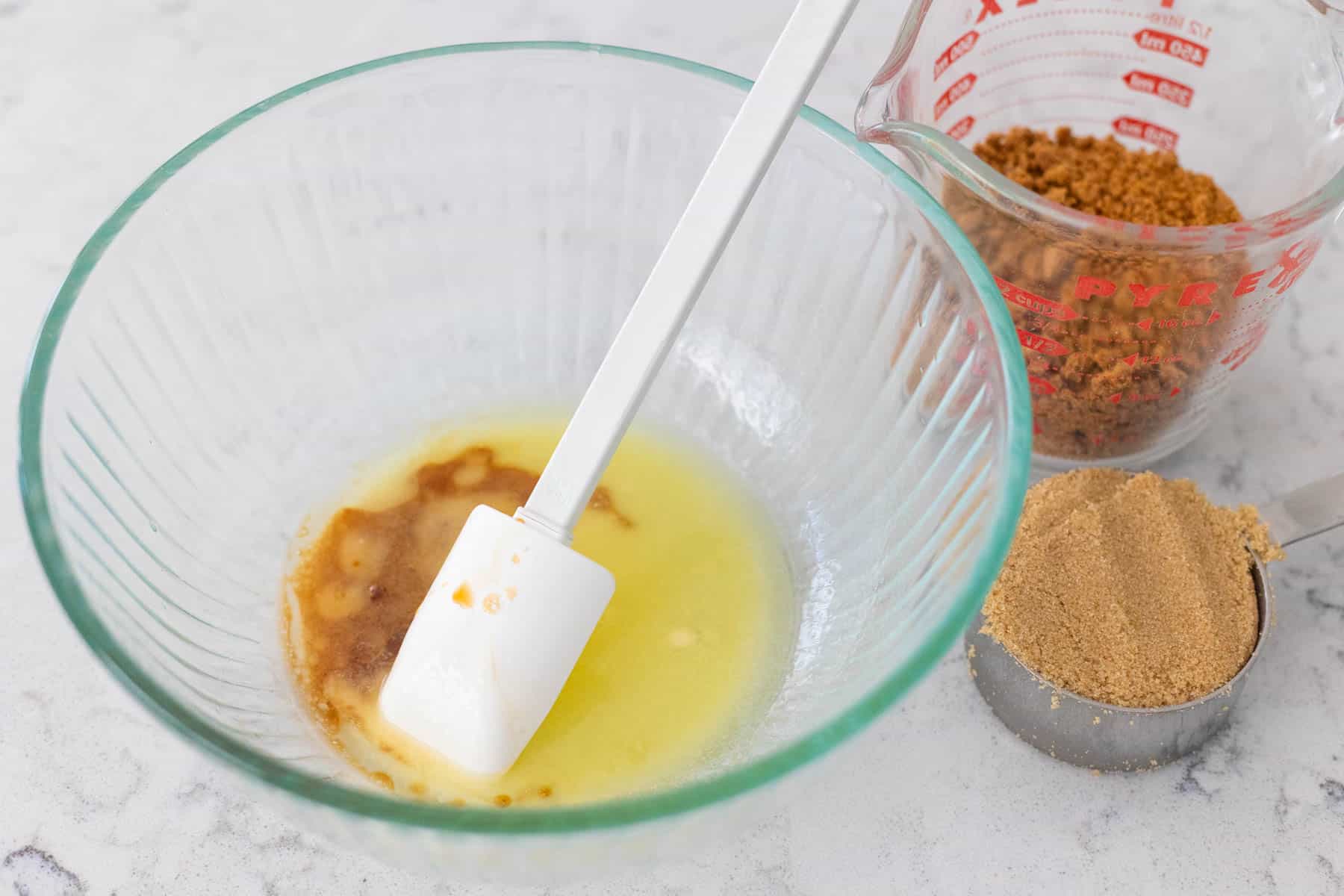 The melted butter, vanilla, cookie crumbs, and brown sugar are ready to be stirred.