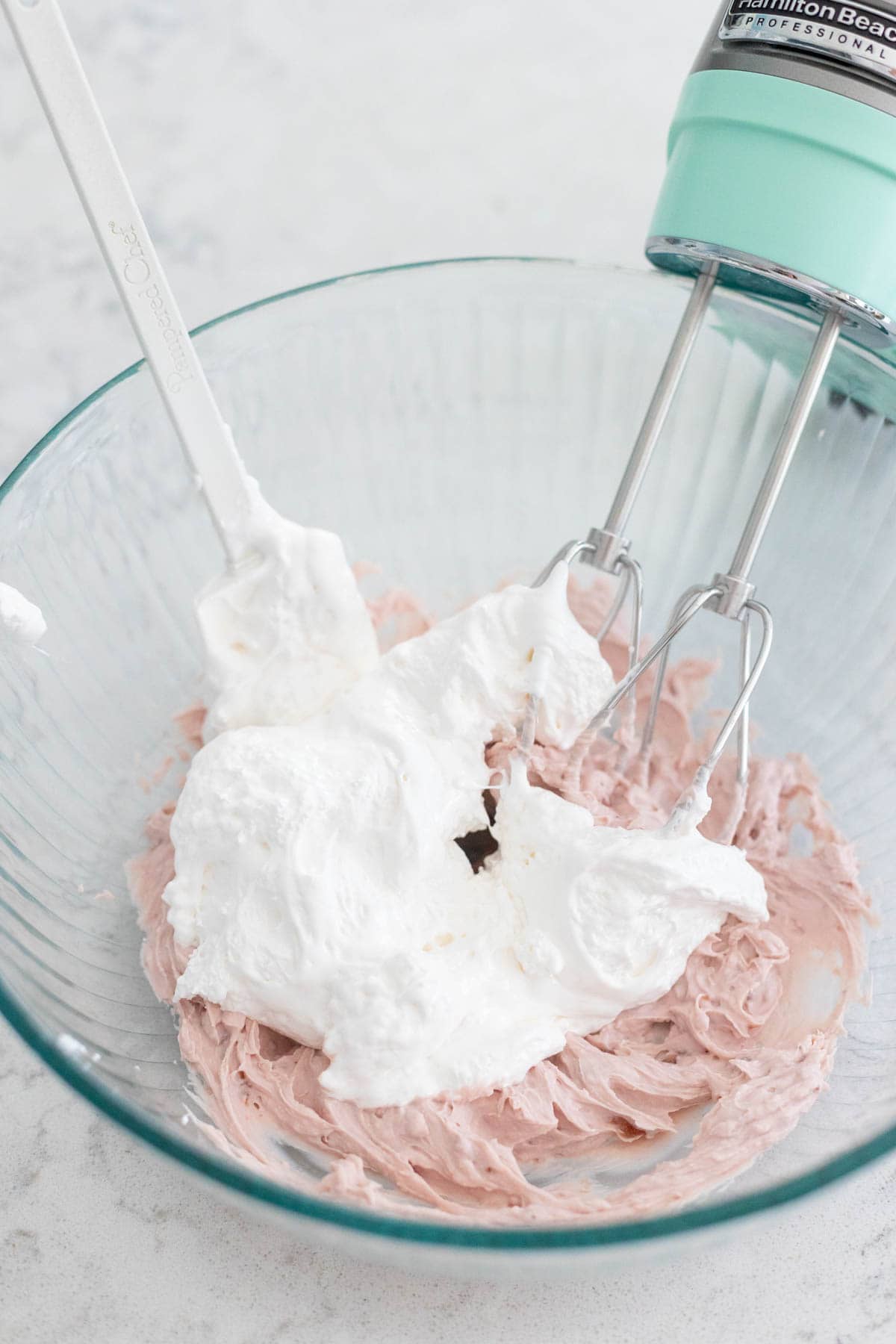 The marshmallow fluff has been added to the mixing bowl.