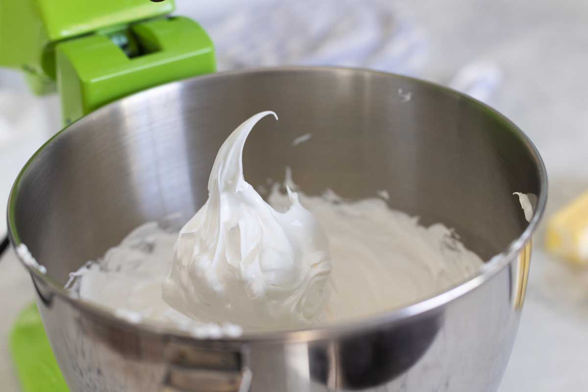 The meringue is now white and glossy, a stiff peak has been pulled to show texture.