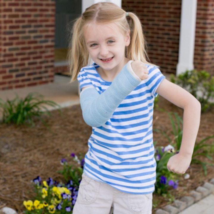 A young girl has an arm cast.