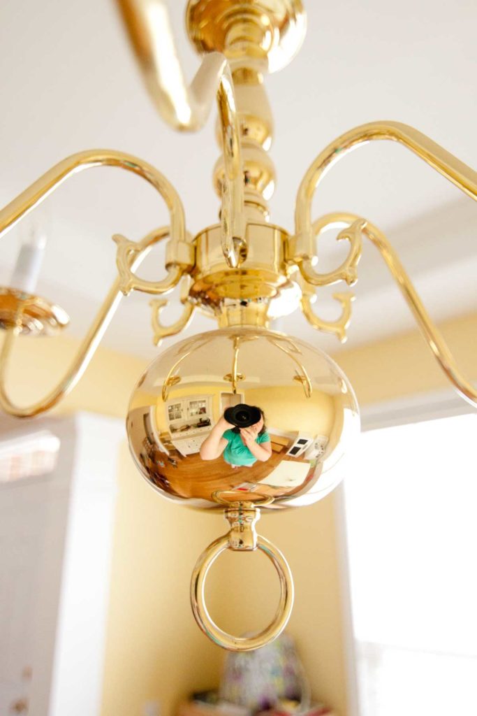 The brass chandelier hanging in the dining room before the transformation.