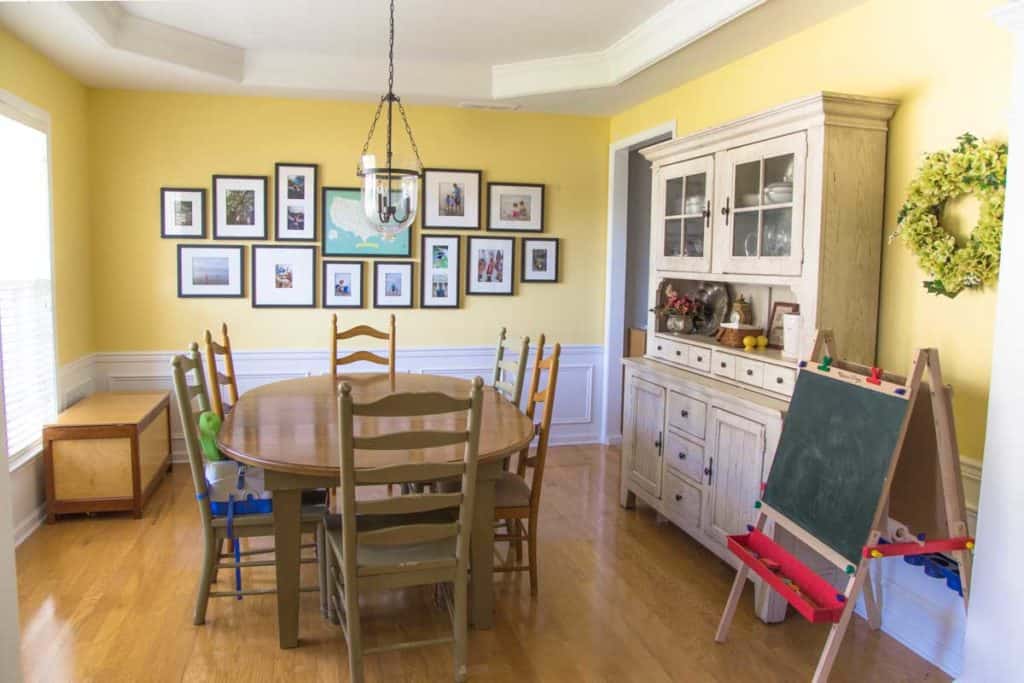 The after photo of the dining room in the entryway is filled with a table and hutch.