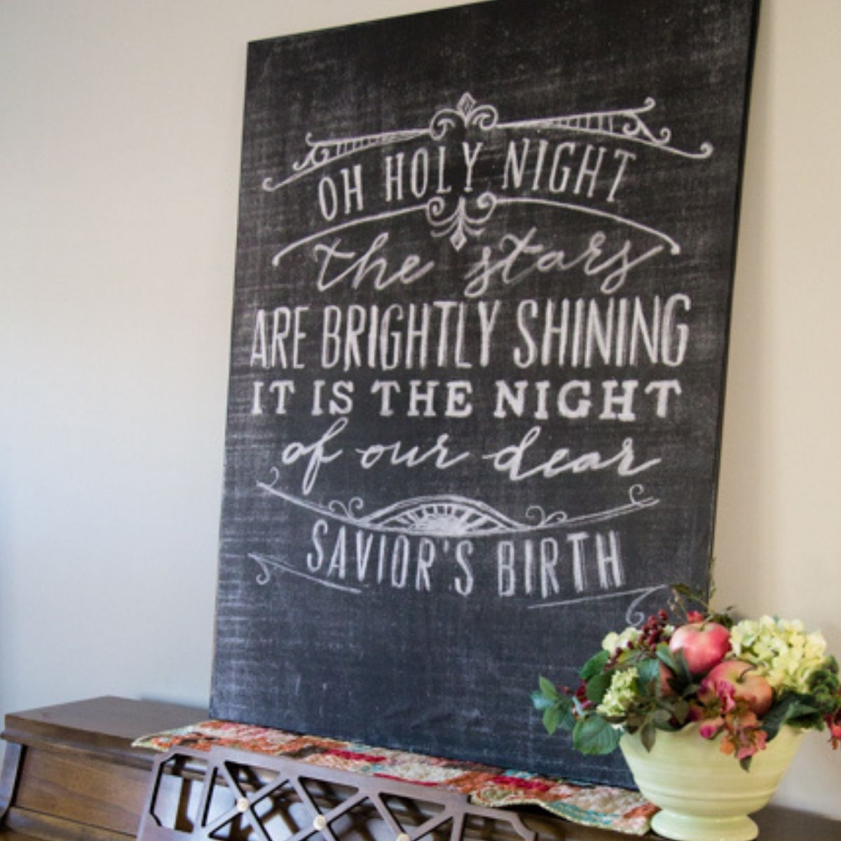 A black chalkboard christmas quotes sign is sitting on a piano.