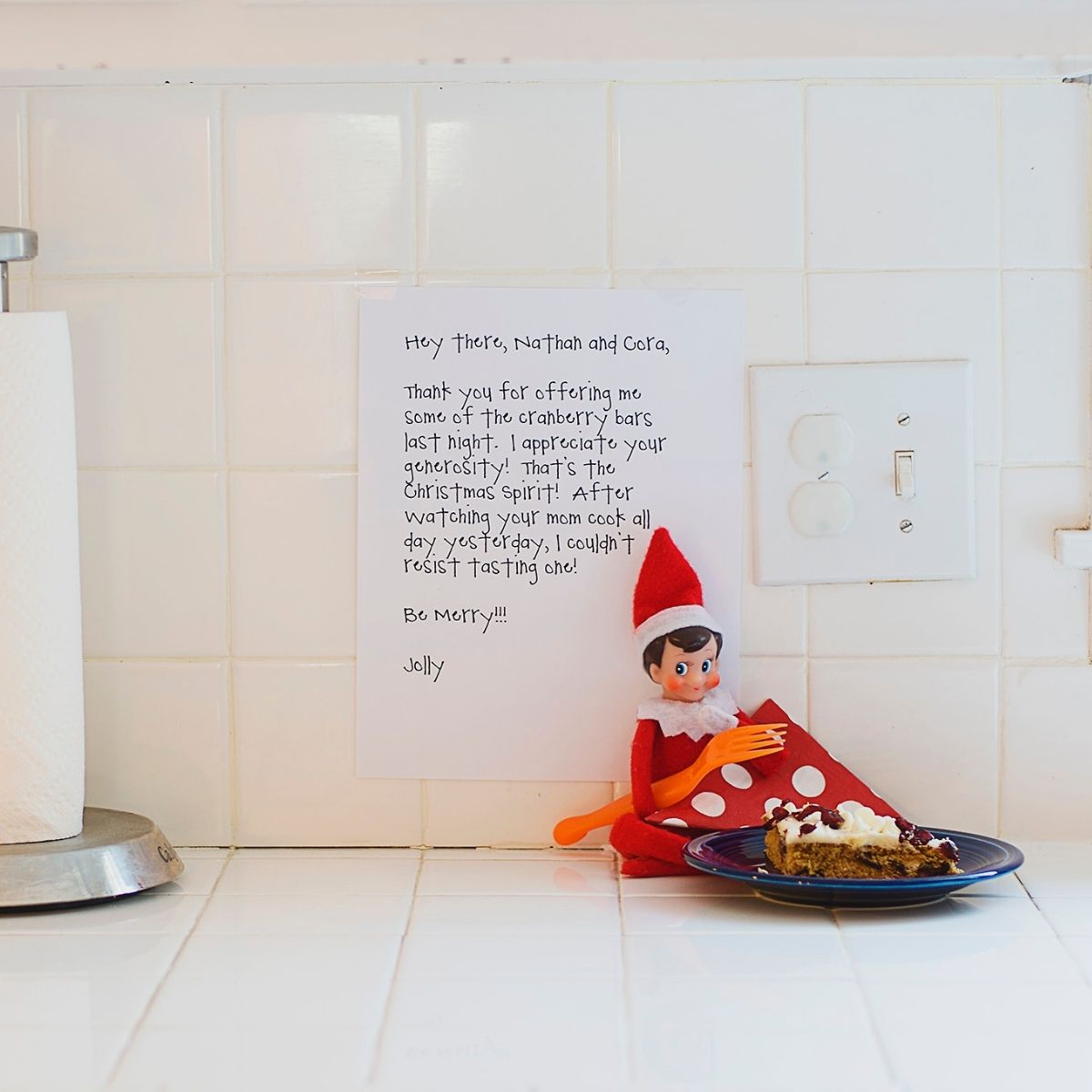 Elf on the Shelf sits on the kitchen counter with a note and some treats.