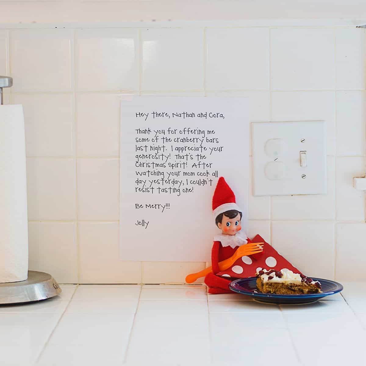 Elf on the Shelf sits on the kitchen counter with a note and some treats.