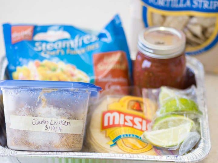 A meal train dinner kit featuring supplies for tacos sits in an aluminum tray for delivery.