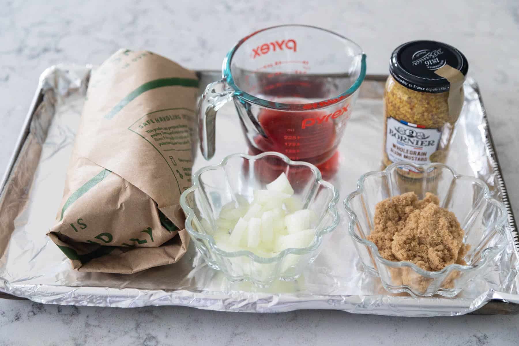 The ingredients to make the salmon are arranged on a baking sheet on the counter.