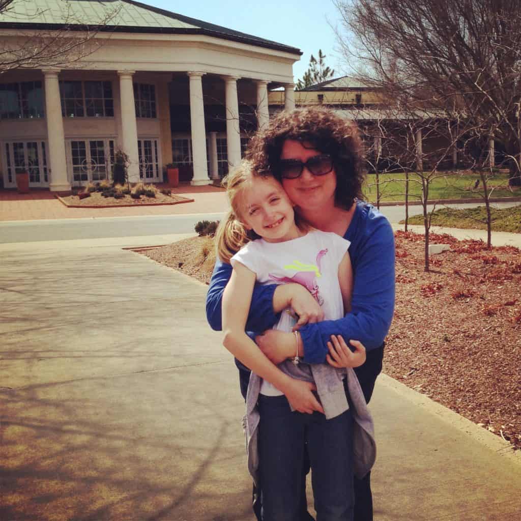 A mom hugs her daughter for a birthday photo.