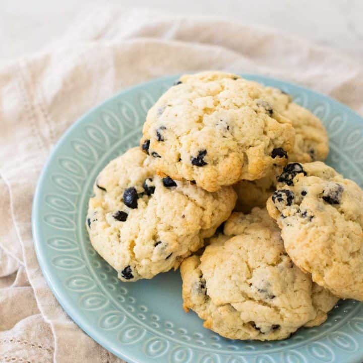 A blue plate has a pile of homemade blueberry scones on top.