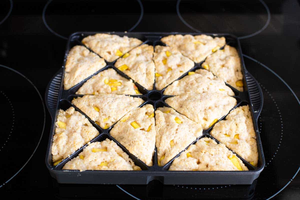 The pan of scones has been baked and are puffed up and golden brown.