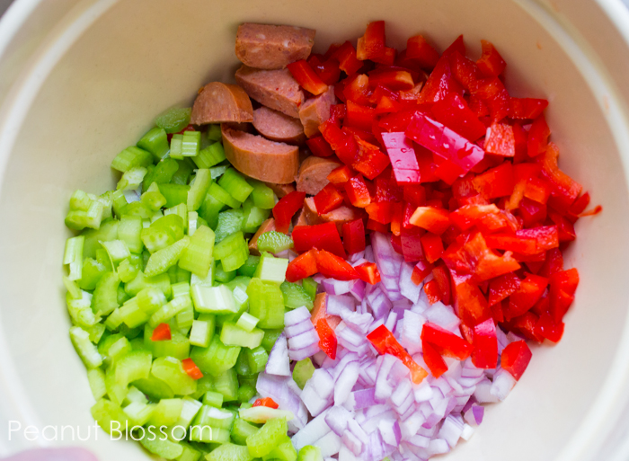 A mixing bowl has all the prepped celery, onion, and peppers for the stew.