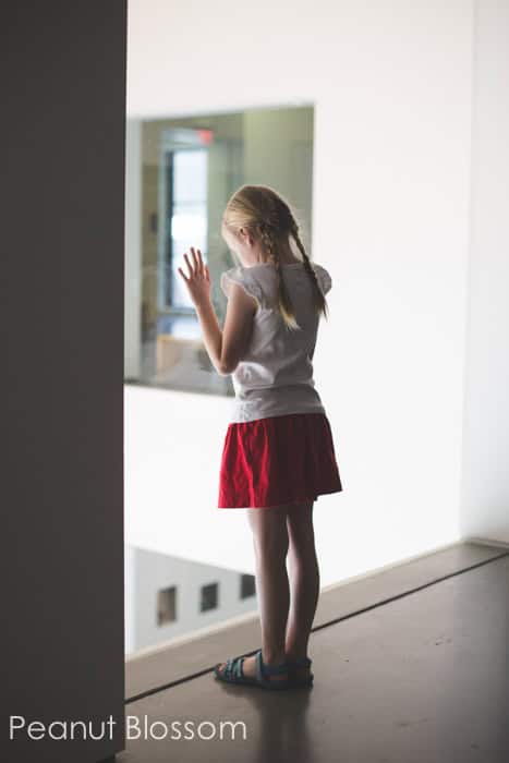 Girl peeking out the window of The Mint Museum Charlotte