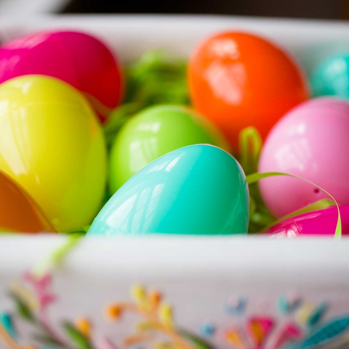 Colorful plastic Easter eggs in a lined basket.