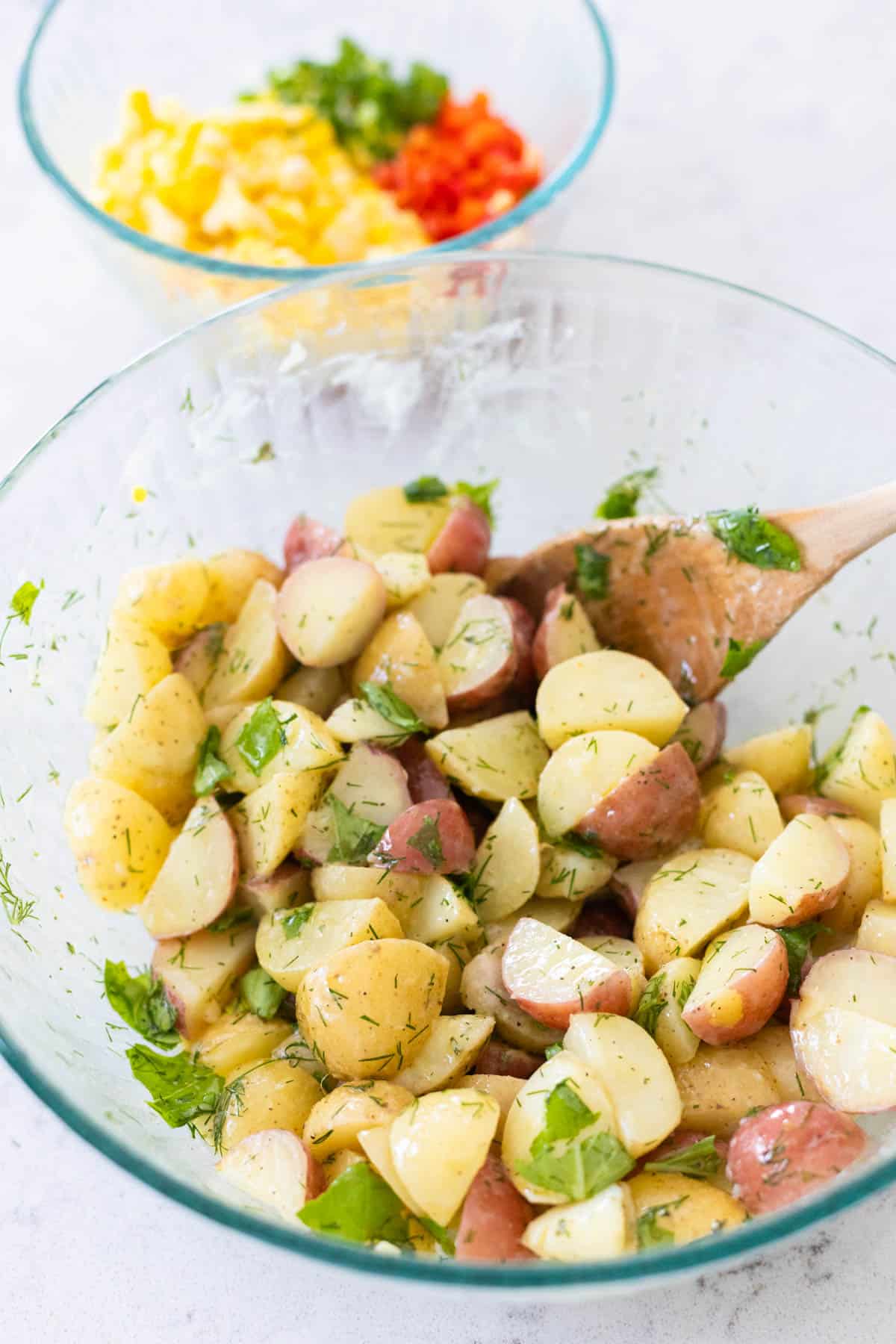 The vinaigrette has been poured over the potatoes and they have been stirred to coat.