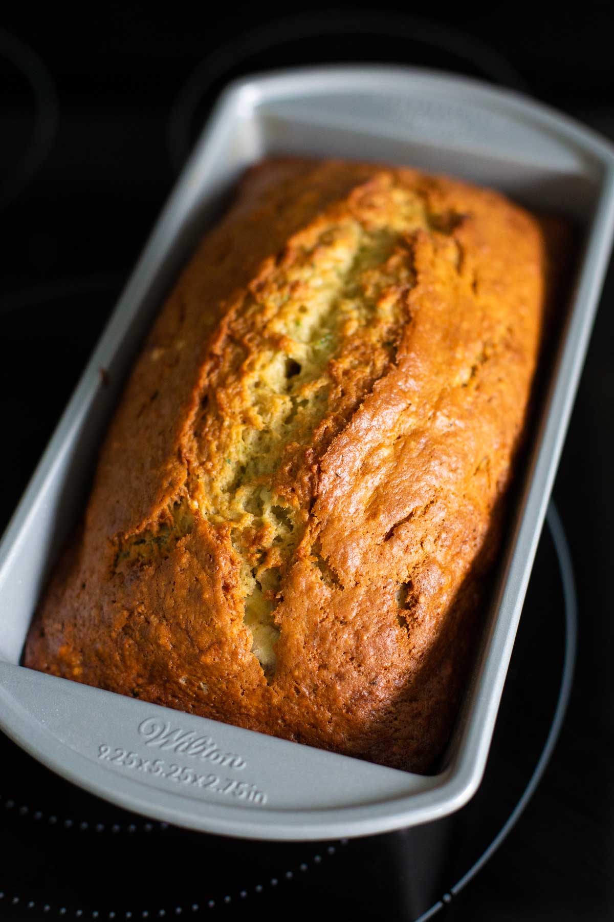 The banana zucchini bread is fresh out of the oven and cools on the stovetop.