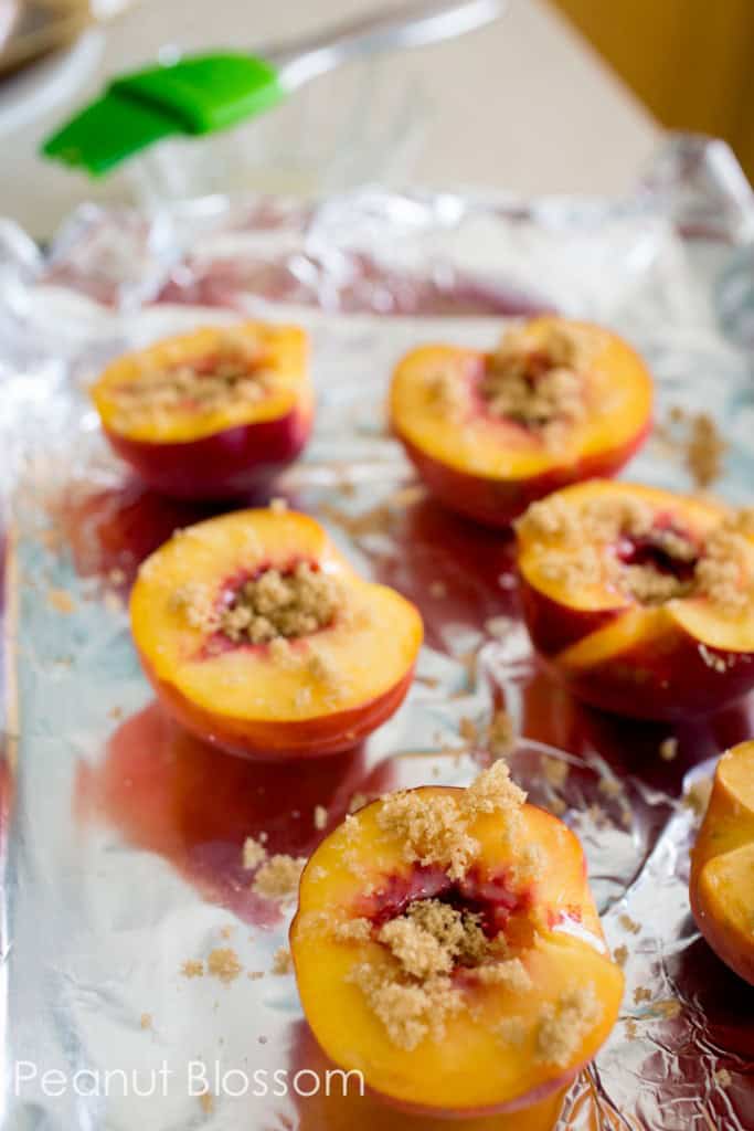 The peach halves have had brown sugar sprinkled over the top.