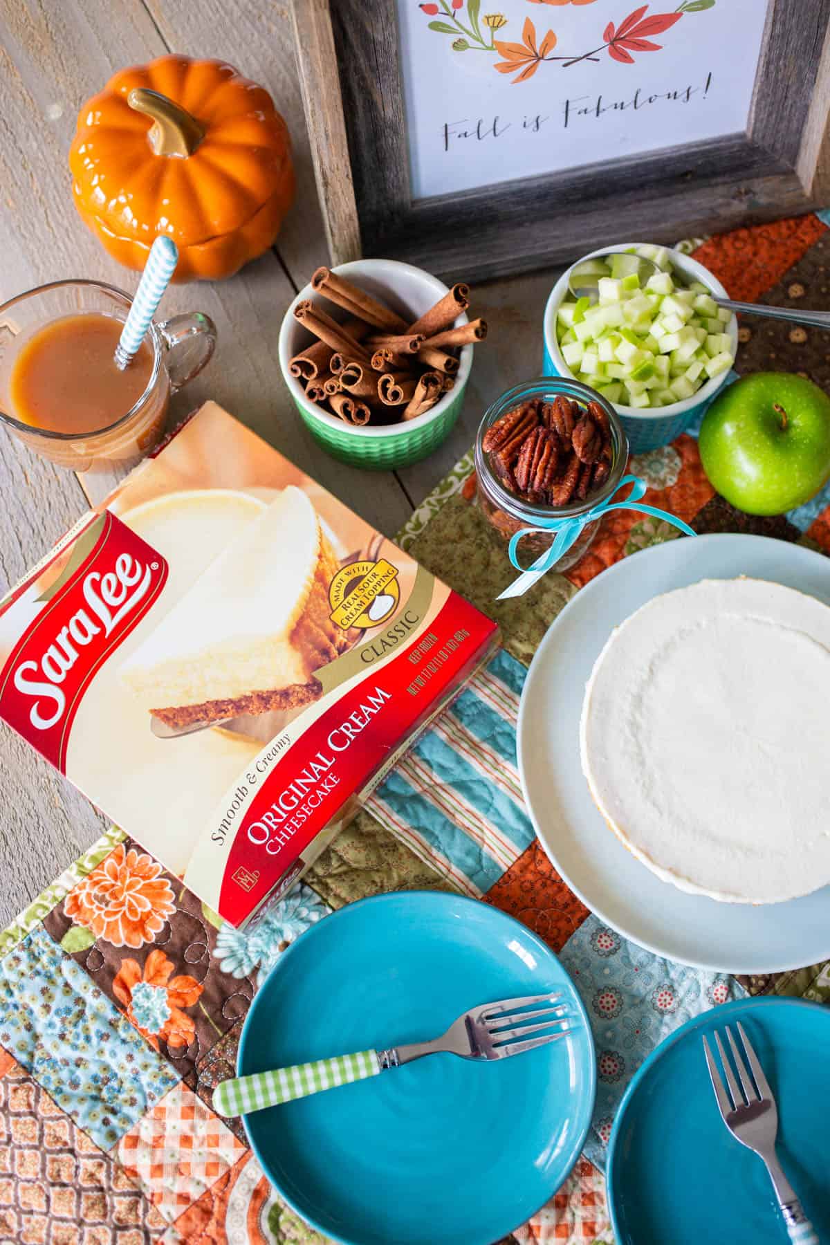 The ingredients to make the cheesecake are displayed on the table next to empty plates.