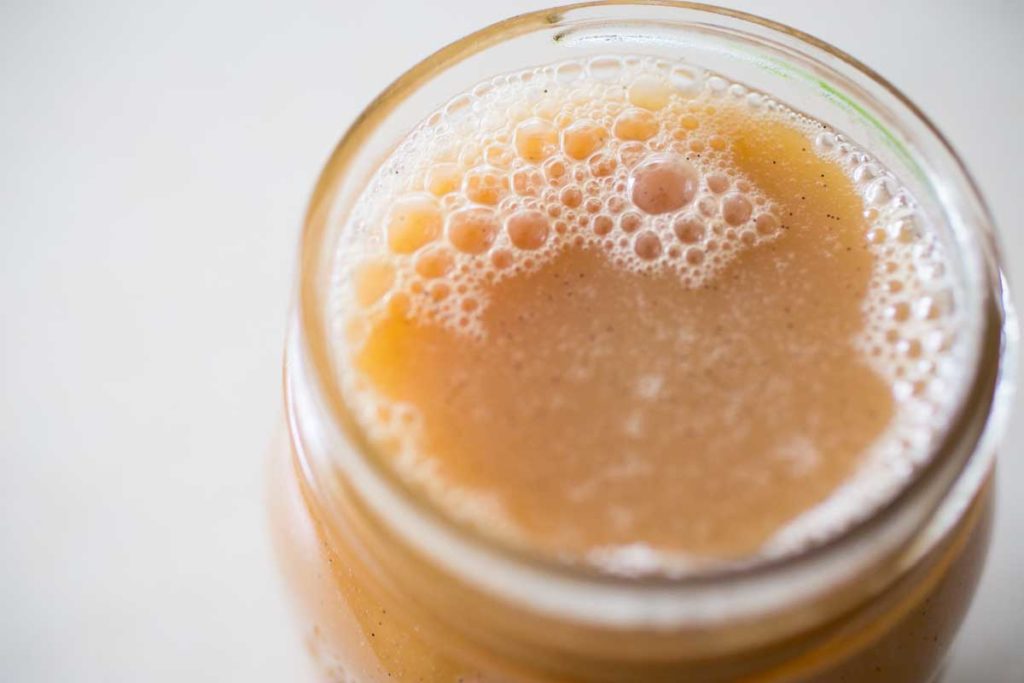 The finished caramel sauce is stored in a mason jar.