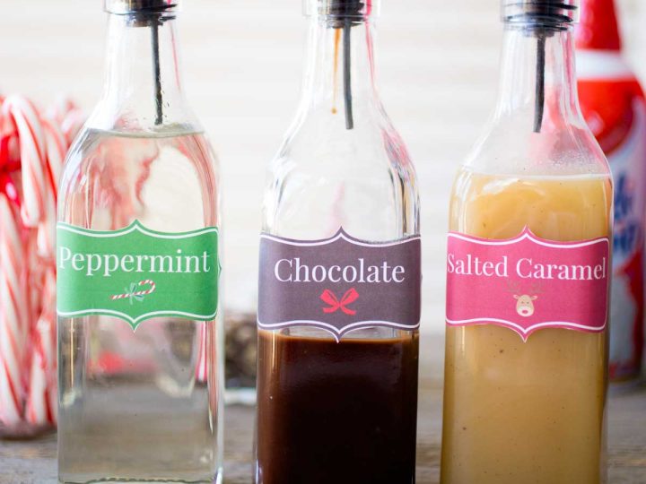 3 tall bottles hold different flavored coffee syrups for a DIY coffee bar.