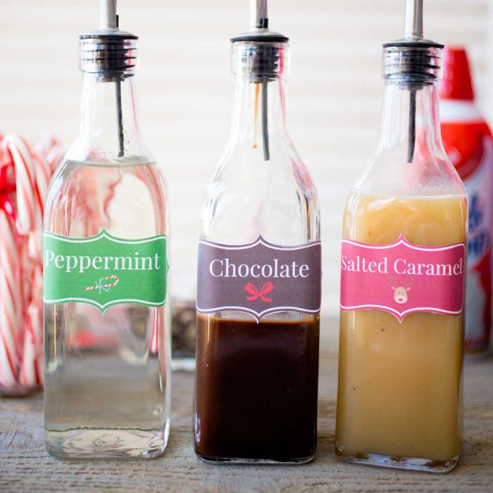 3 tall bottles hold different flavored coffee syrups for a DIY coffee bar.