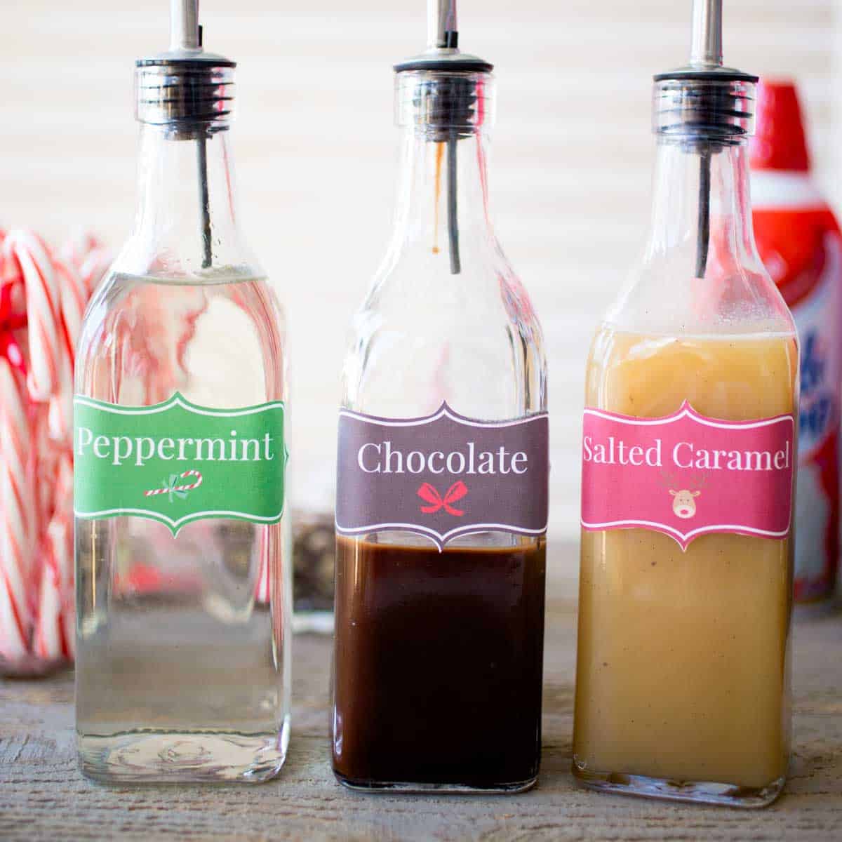 3 tall bottles hold different flavored coffee syrups for a DIY coffee bar.