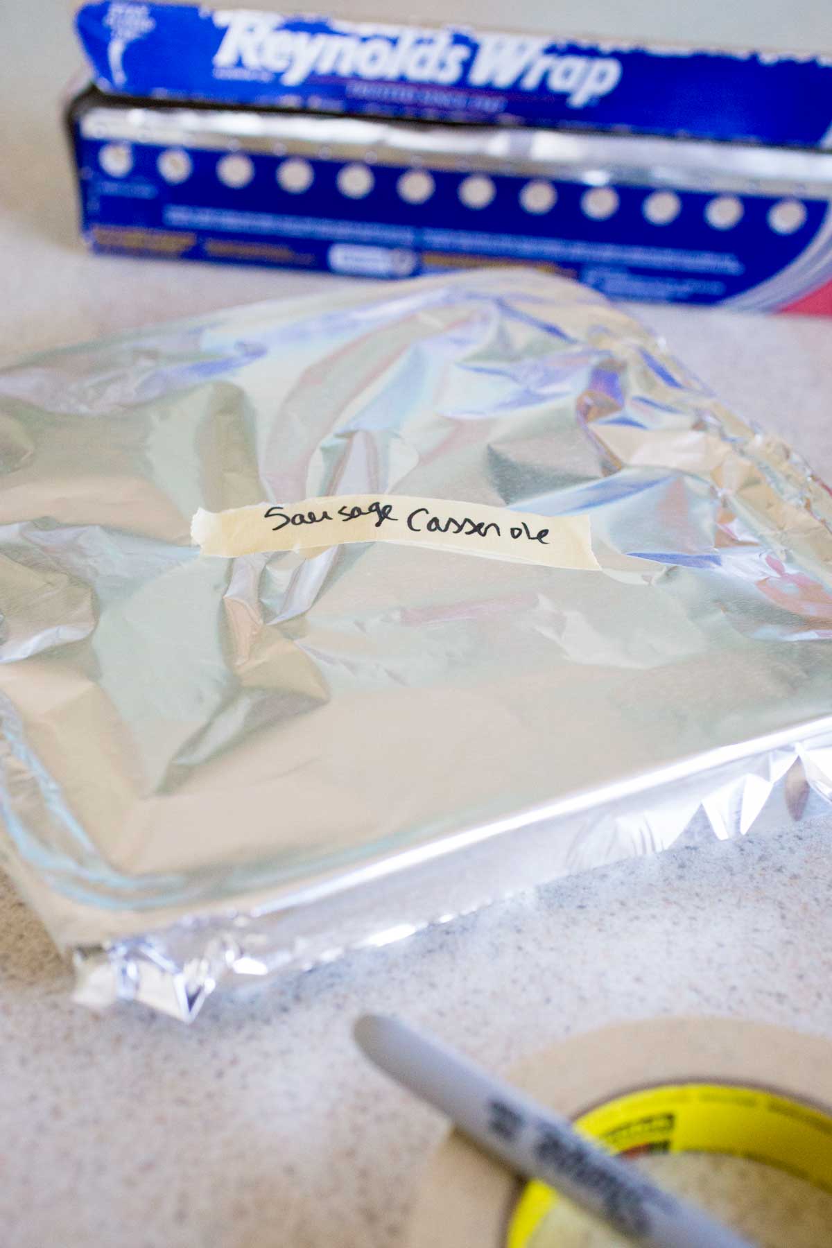 The italian sausage casserole has been wrapped in aluminum foil for the freezer.