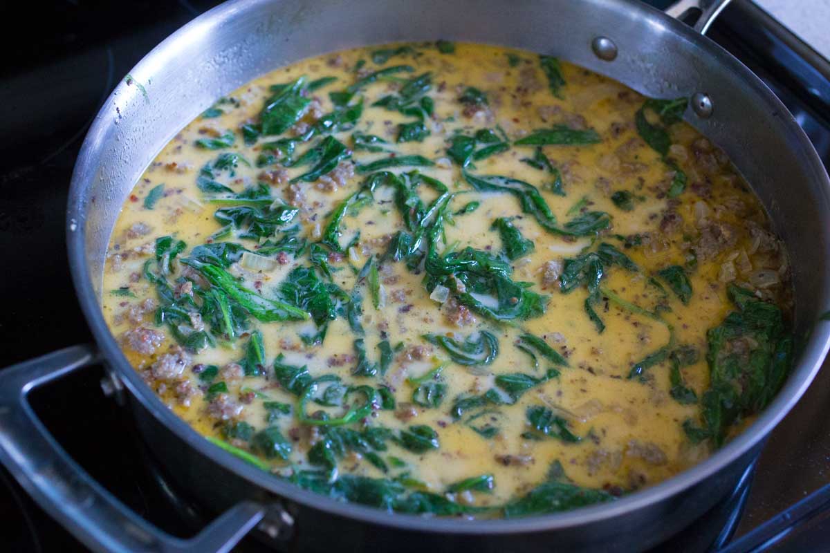 The spinach has wilted and a little cream has been added to the sauce.