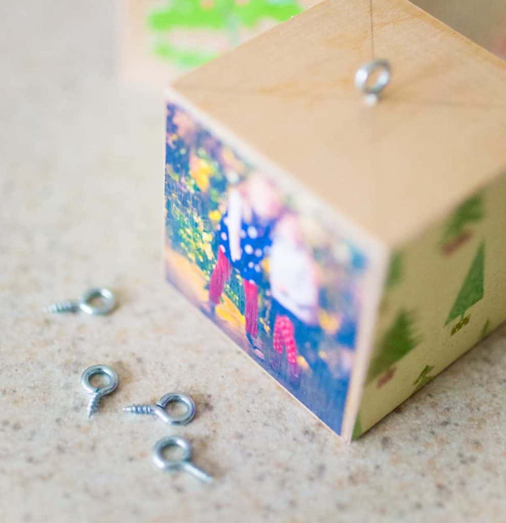 Pencil marks show the center of the top of the wooden block where a loop screw should be added for hanging.